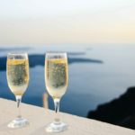 Two champagne glasses on terrace overlooking water